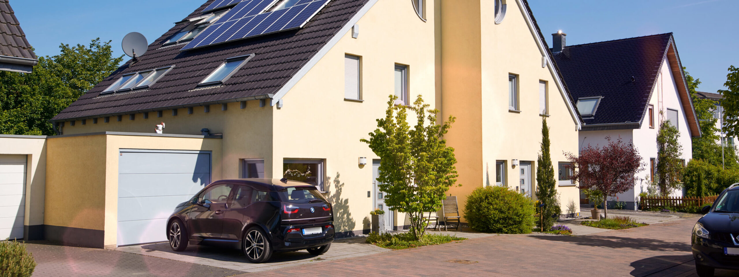 E-Auto lädt mit der Energie aus der Solaranlage auf dem Dach des Hauses